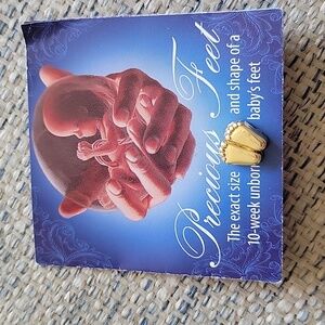 Goldtone Lapel pin of size of an unborn baby at 10 weeks. On original card.